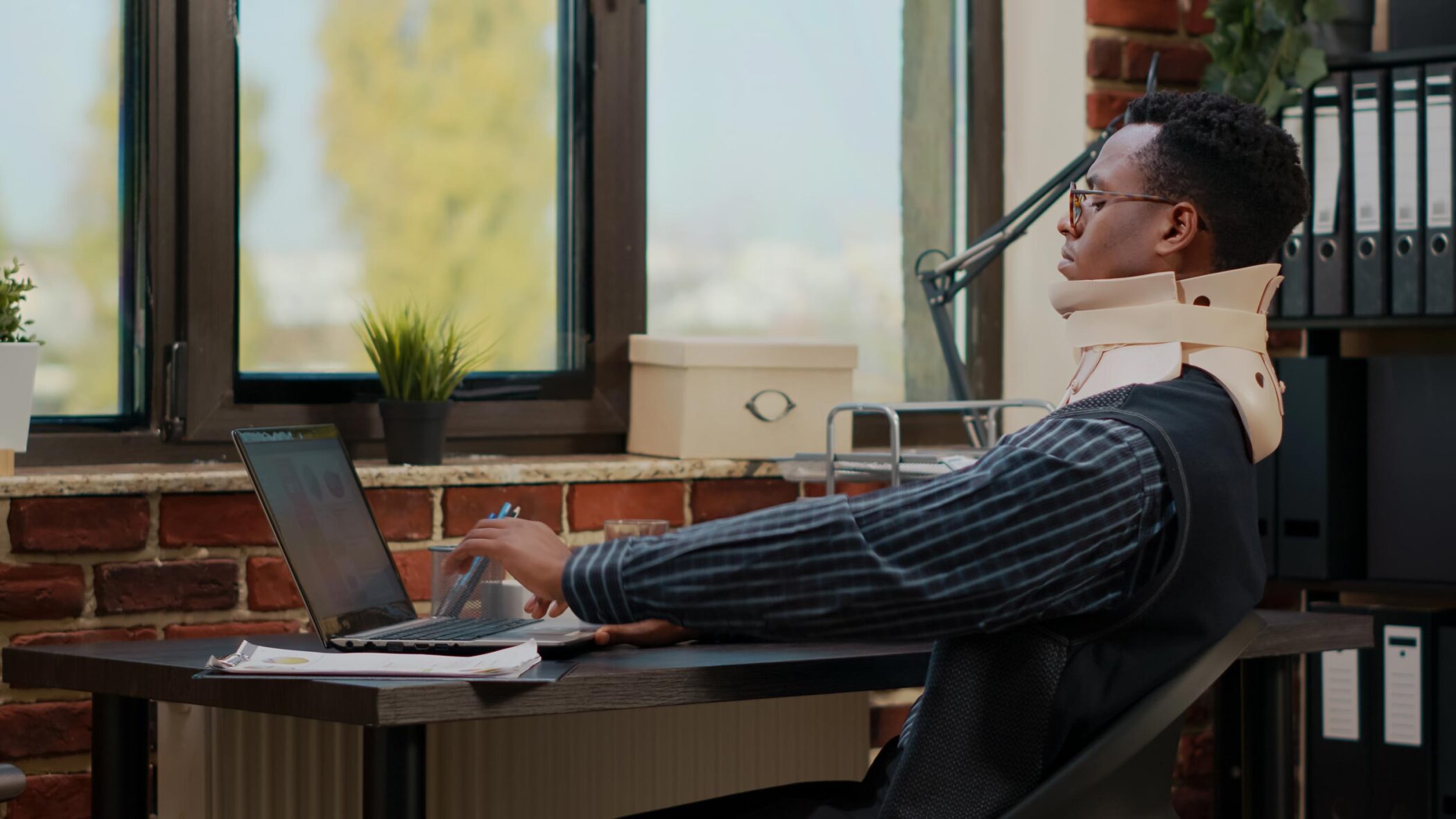 business man wearing cervical neck collar work after vertebrae injury startup office injured employee using medical foam while he works with laptop plan com